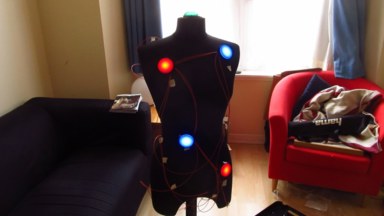 The controller during development, with the buttons all lit up, and all the wires visible against the mannequin's body.